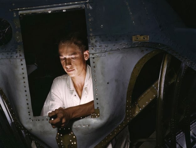 #172 As an NYA (National Youth Administration) trainee working inside the nose of a PBY, Elmer J. Pace is learning the construction of Navy planes, at Corpus Christi Naval Air Base, in Texas, in August of 1942