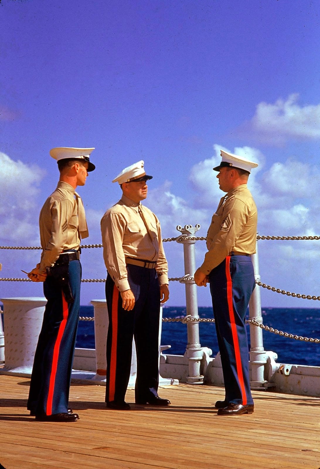 #42 Three American Marines in dress uniforms talk aboard an unidentified ship during the US Navy’s Pacific fleet maneuvers near Hawaii, September 1940.