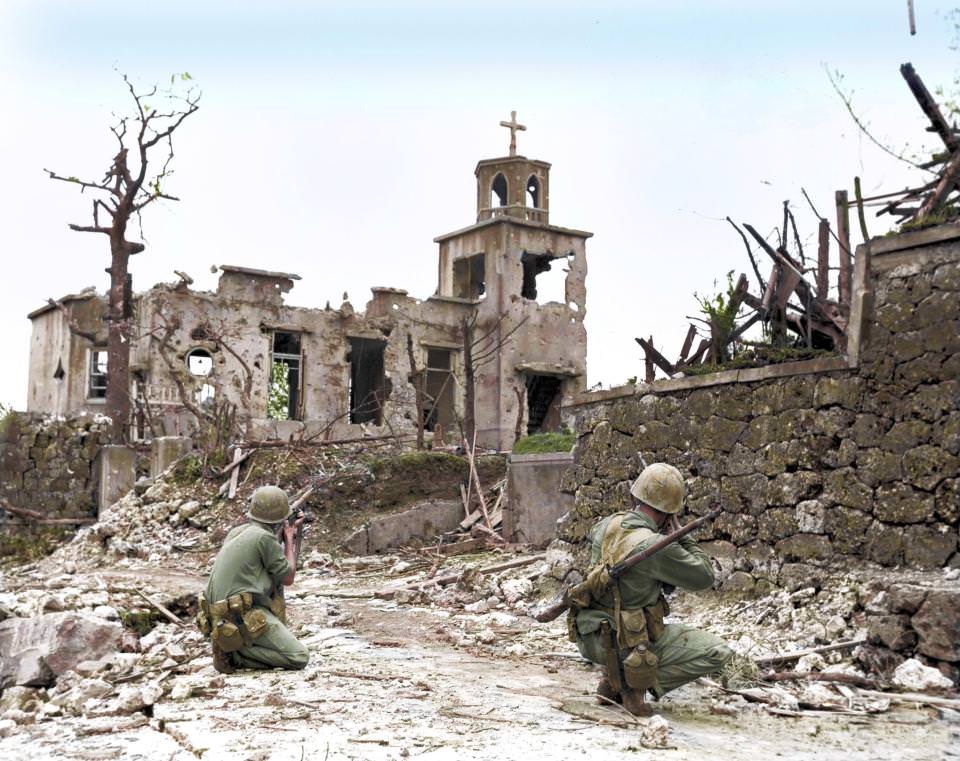 #2 While a patrol moves in from the rear, two United States Marines cover a Japanese sniper hiding in a church, below Shuri Castle on Okinawa, 1945.