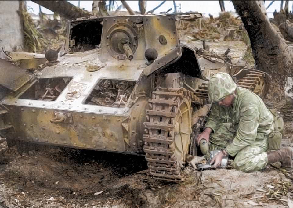 #53 A U.S. Marine shares his water bottle with a stray kitten found under a burned-out Japanese tank on Tarawa in 1943.