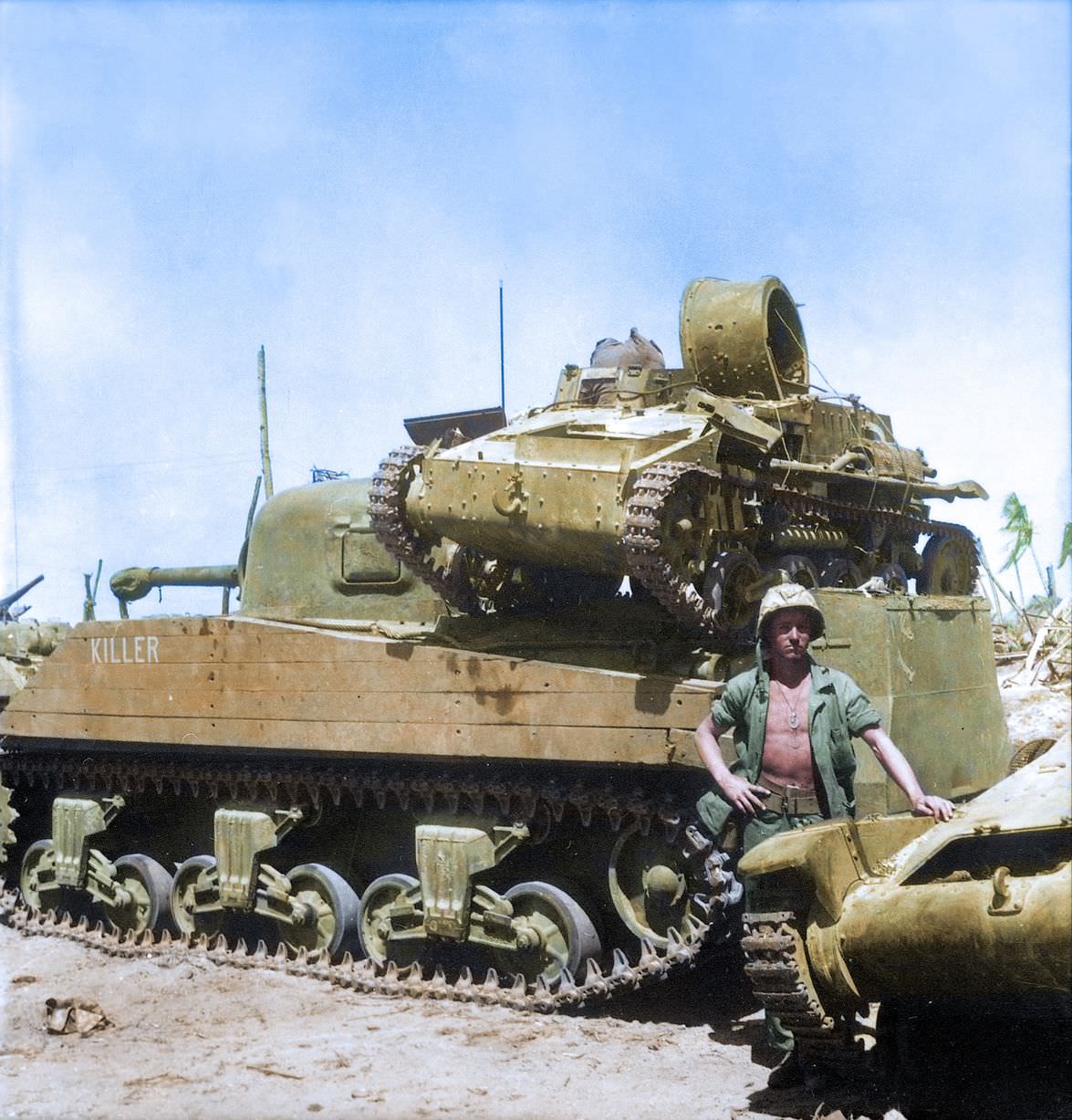 #63 Private First Class N. E. Carling stands beside the American M4 Sherman medium tank ‘Killer’ on Kwajalein Atoll.