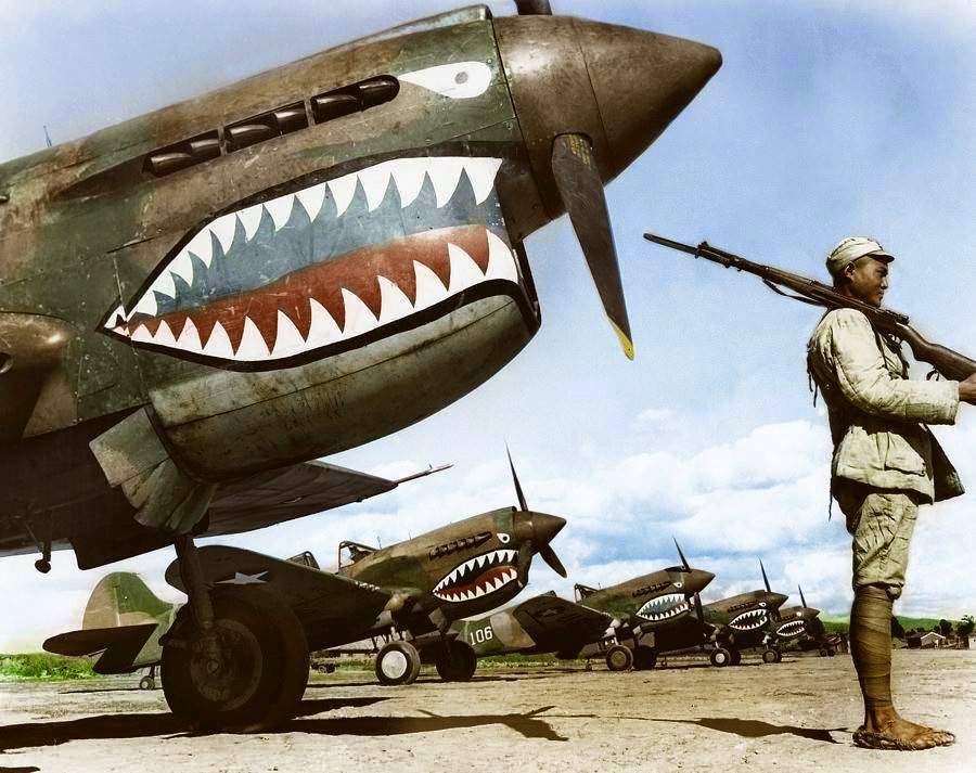 #26 A Chinese Nationalist soldier guards a row of Curtiss P-40 ‘Warhawks’ flown by the ‘Flying Tigers’ of the American Volunteer Group (AVG). July, 1942.