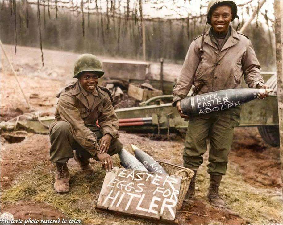 #28 T/5 William E. Thomas and Pfc. Joseph Jackson prepare a gift of special “Easter Eggs” for Adolf Hitler and the German Army. Scrawling such messages on artillery shells in World War II was one way in which artillery soldiers could humorously express their dislike of the enemy.
