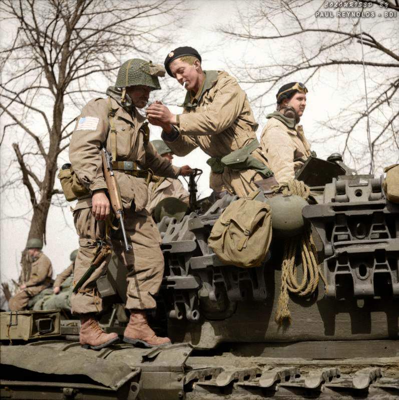 #74 A paratrooper from the American 17th Airborne Division gets a light from a Churchill tank crewman of 6th Guards Armoured Brigade near Dorsten in North Rhine-Westphalia, Germany, 29th of March 1945.