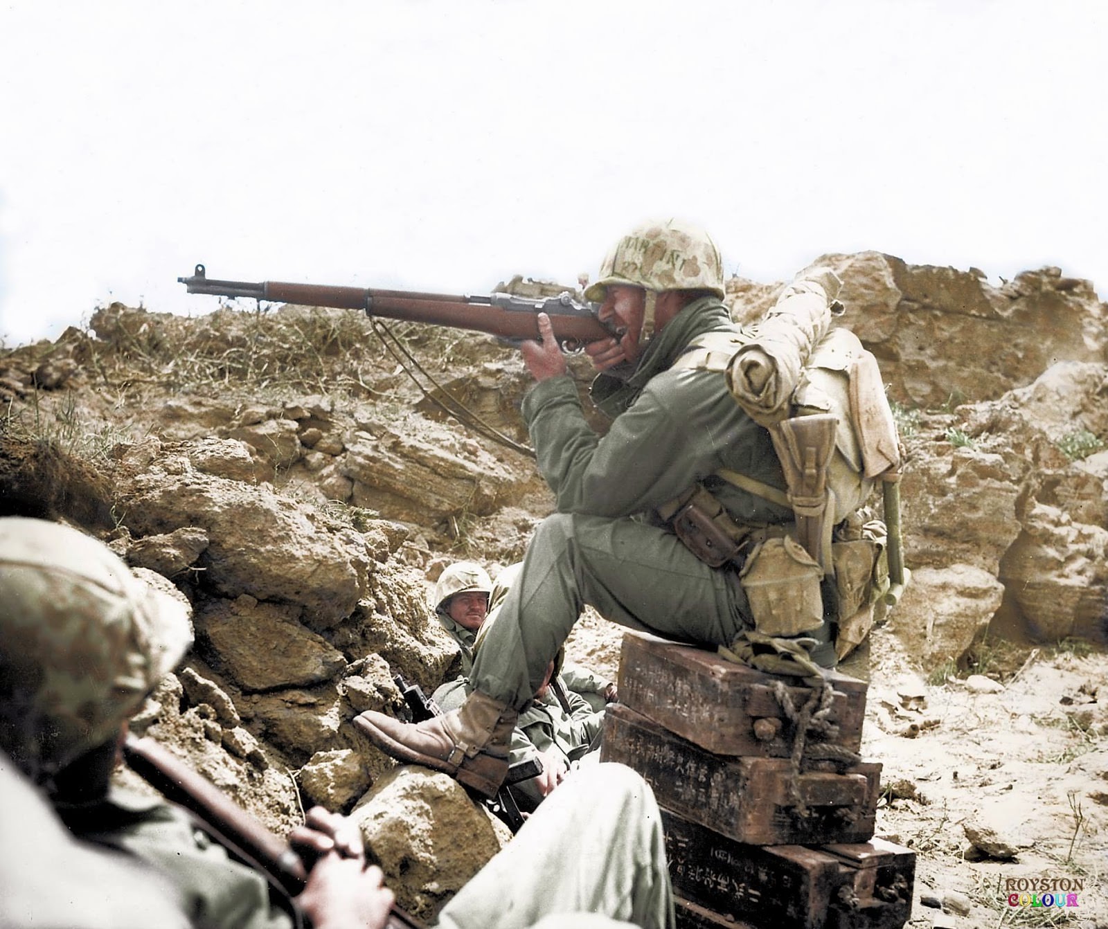 #86 An American Marine aiming his Garand M1 rifle, whilst perched on Japanese ammunition crates on the Island of Iwo Jima, c. February/March 1945