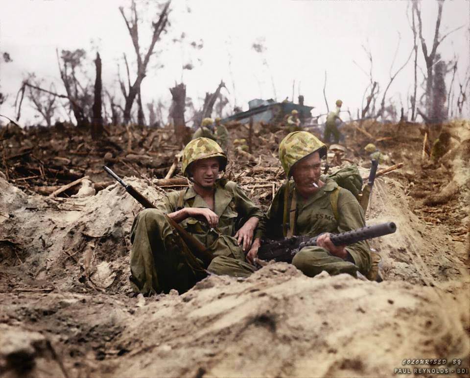 #88 Marine Pfc. Douglas Lightheart (right) cradles his .30 caliber M1919 Browning machine gun in his lap, while he and Marine Pfc. Gerald Thursby Sr. take a cigarette break, during mopping up operations on Peleliu on 14th September 1944.
