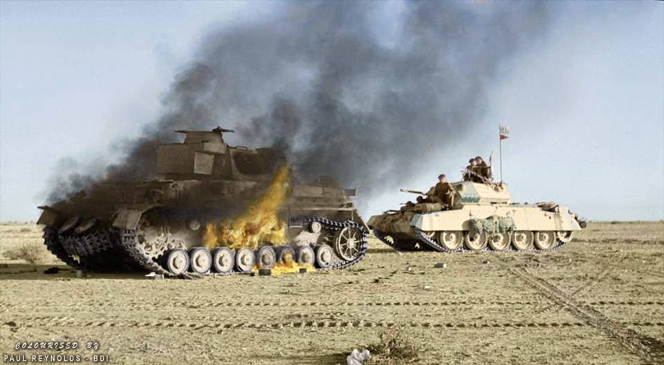 #89 A British Crusader tank passes a burning German Panzer IV tank during ‘Operation Crusader’. Cyrenaica (the eastern province of Libya). Winter 1941