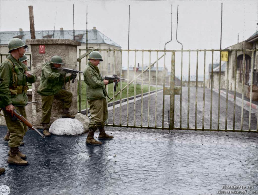 #92 US troops from Combat Command B of the U.S. 14th Armored Division entering the Hammelburg Prison in Germany by opening the main gate with bursts of their M3 “Grease Guns”. Hammelburg, Germany. April 6, 1945