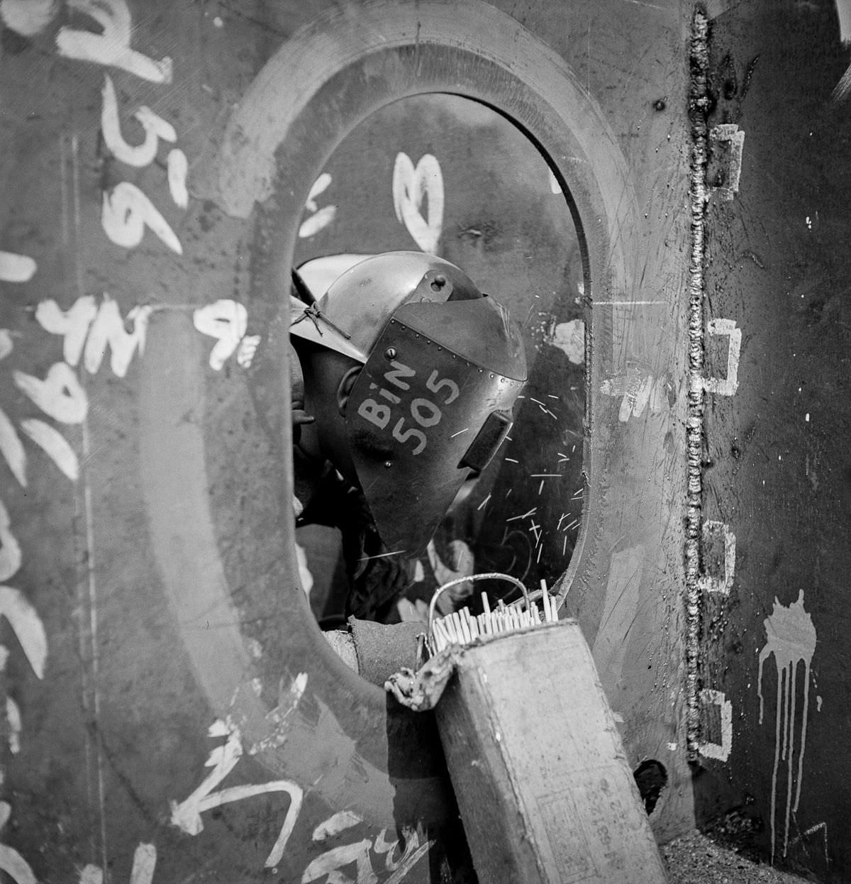 #10 A worker welds a floor to a vertical keel