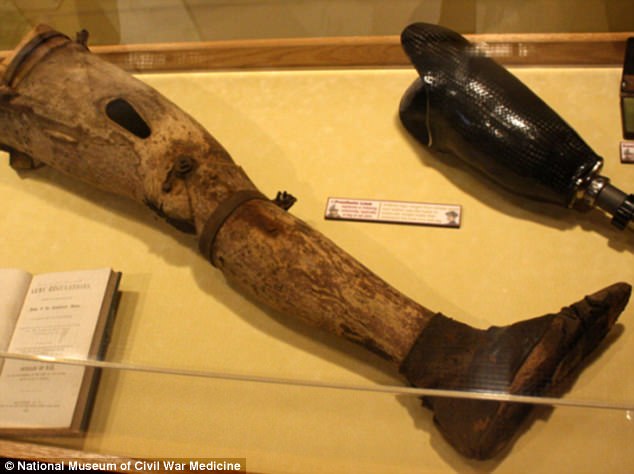 #43 This prosthetic leg made of wood is a full left leg, articulated at the knee, with a leather shoe covering the foot. It still retains some of the original flesh-colored paint.