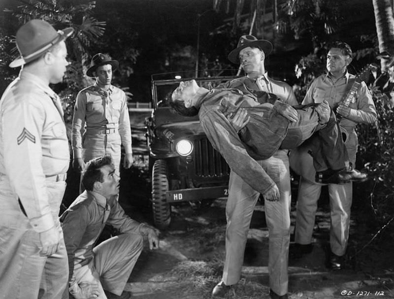Montgomery Clift looking up as Burt Lancaster carries fellow fallen man in a scene from the film ‘From Here to Eternity,’ 1953.