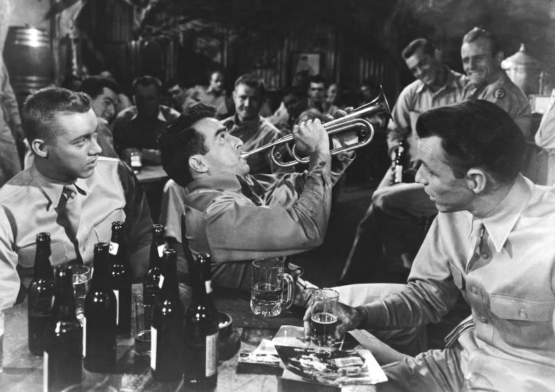 Montgomery Clift plays the trumpet while Frank Sinatra watches in a scene from the film ‘From Here to Eternity,’ 1953.