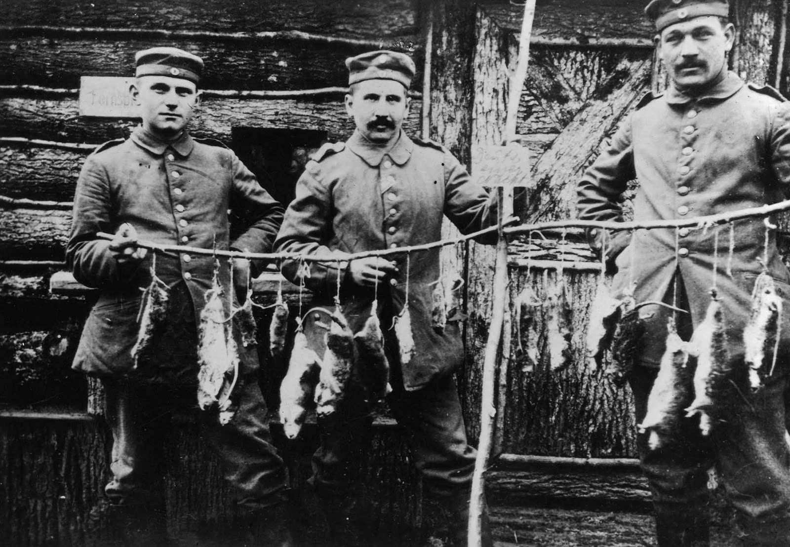 #4 Three German soldiers display rats killed in their trench the previous night. 1916.