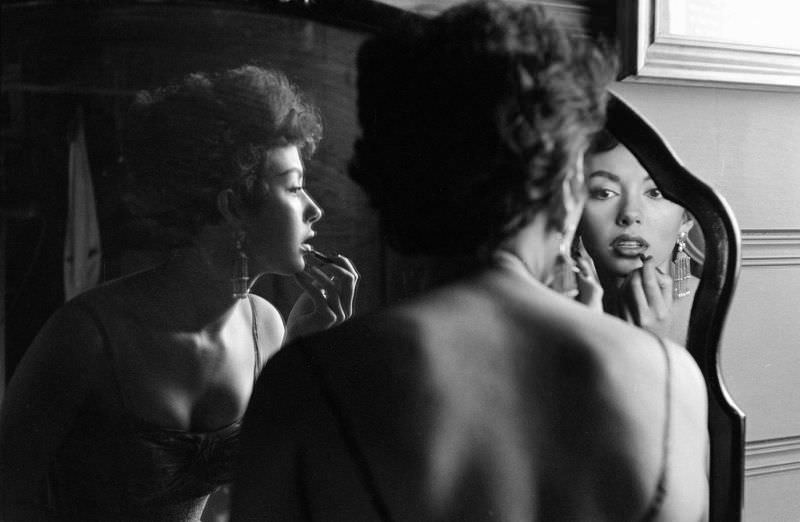 #29 Rita Moreno puts on makeup in the mirror, Hollywood, 1954.
