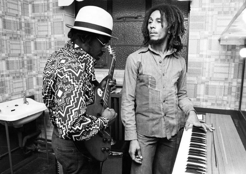 Aston ‘Family Man’ Barrett and Bob Marley of The Wailers playing guitar and keyboards backstage at the Odeon, Birmingham, United Kingdom, July 18, 1975