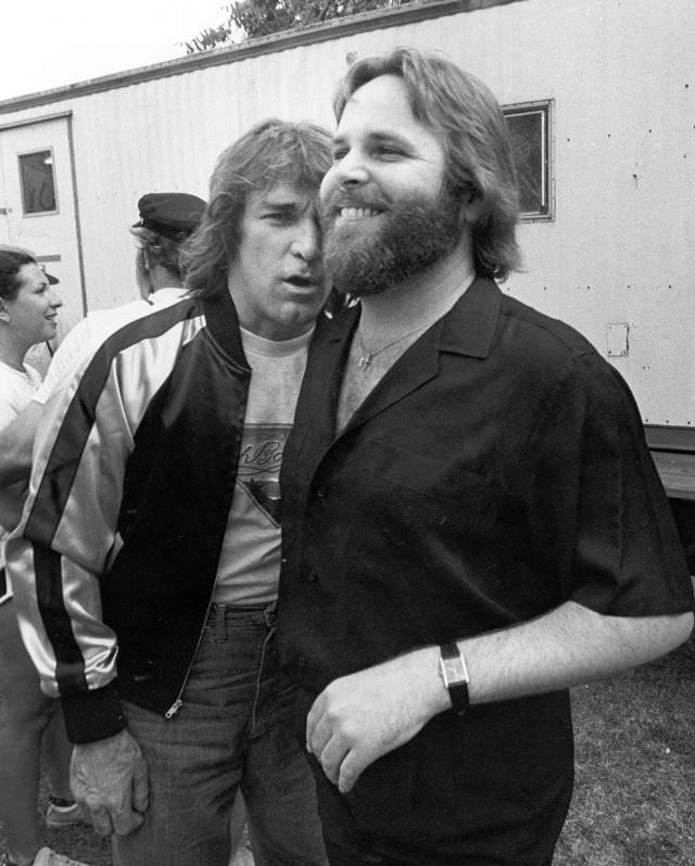 #36 Dennis Wilson and Carl Wilson of The Beach Boys hang out after an outdoor concert in 1975