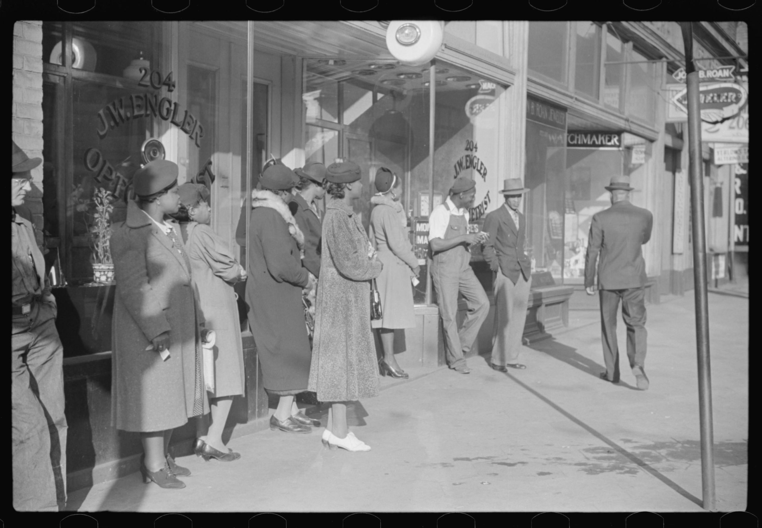 #43 Domestic servants waiting for streetcar on way to work early in the morning. Mitchell Street, Atlanta, Georgia. May, 1939