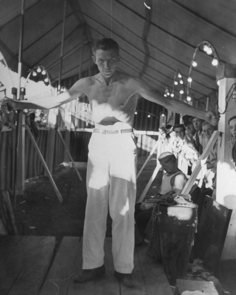 Silas Whaley, the man without a stomach, pulling his stomach in so far it seems like he doesn’t have one as he awes onlookers in carnival sideshow at the Greenbrier Valley Fair, 1938