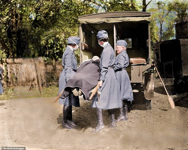 Red Cross nurses in Washington demonstrate patient care during the outbreak by carrying one on a stretcher into a car.