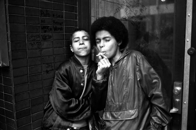 Child prostitutes or also known as teenage hustlers share a cigarette while waiting for customers on 7th Avenue near 42nd Street.