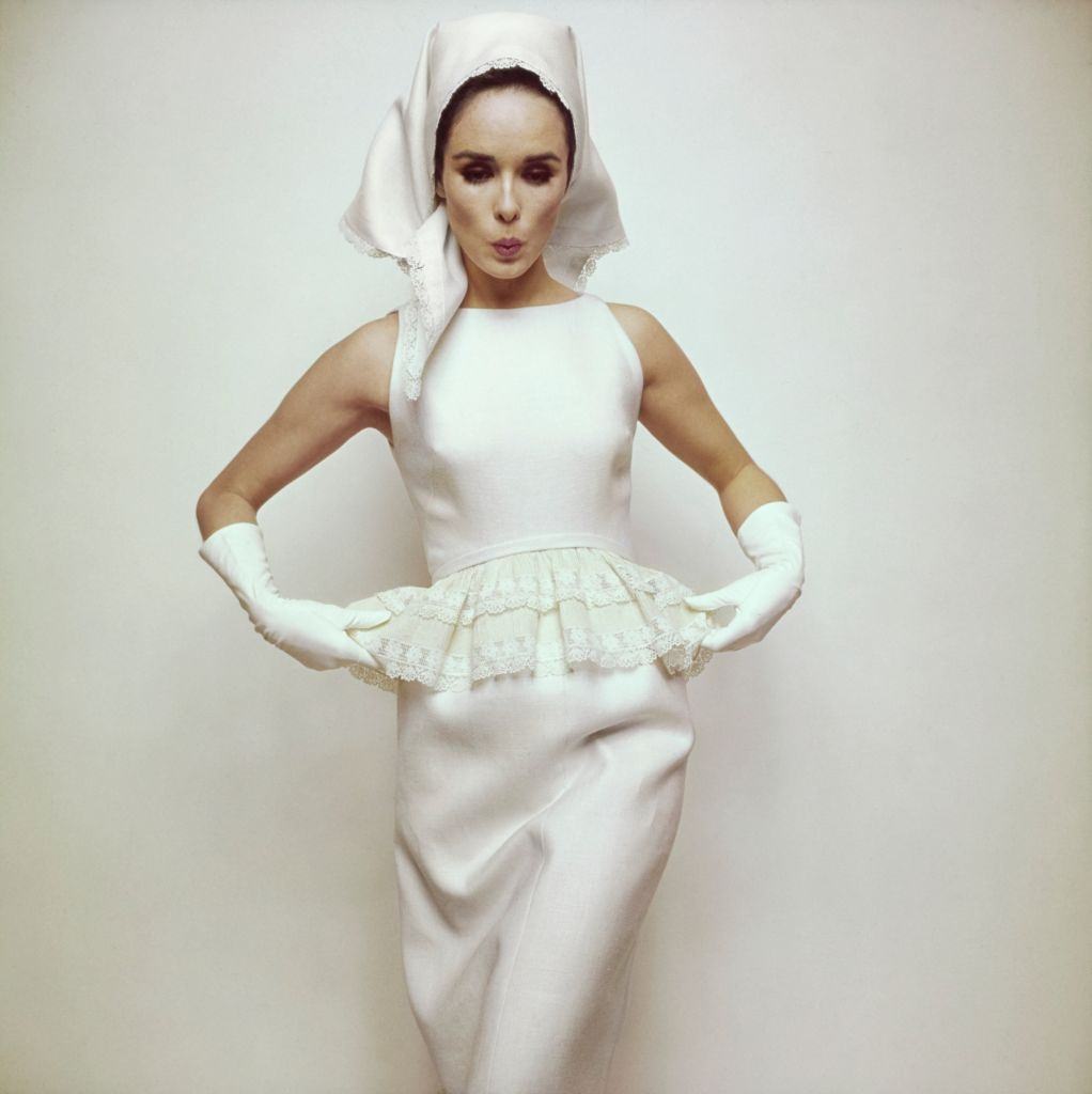 #24 Model wearing white ‘peplum of lace’ on white sleeveless dress, Vogue 1963
