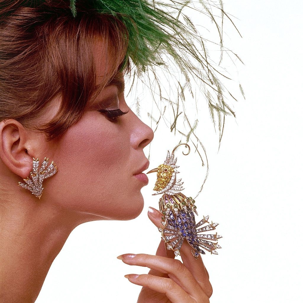 #33 Fashion model holding jeweled bird made-up of precious and semi-precious stones, Vogu 1963