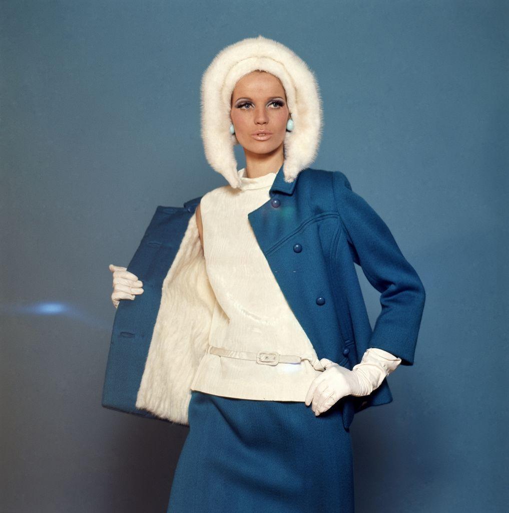 #55 Model Veruschka wearing a David Kidd for Jablow mink-lined wool suit with a moire belted top and Amrose hat, Vogue 1965