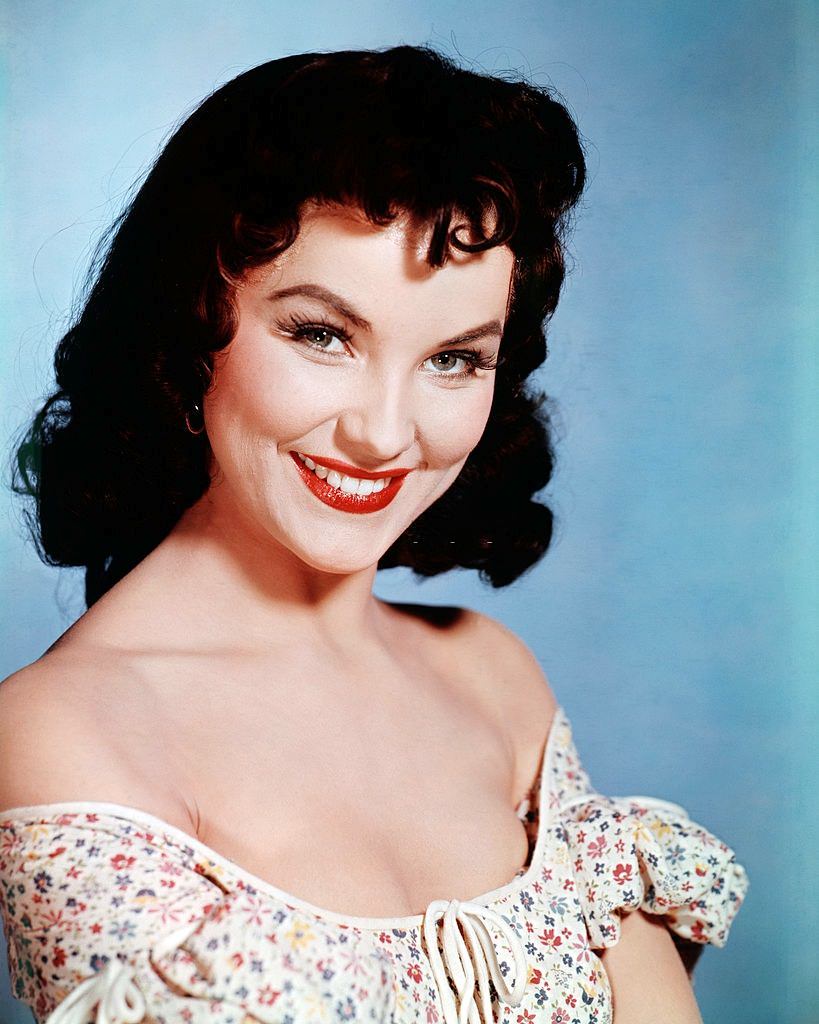 #30 Debra Paget wearing an off-the-shoulder dress, 1955