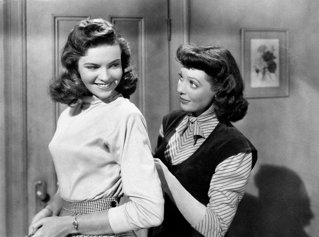 #43 Loretta Young repairing the dress of Debra Pagetin the film Mother Is a Freshman, 1949