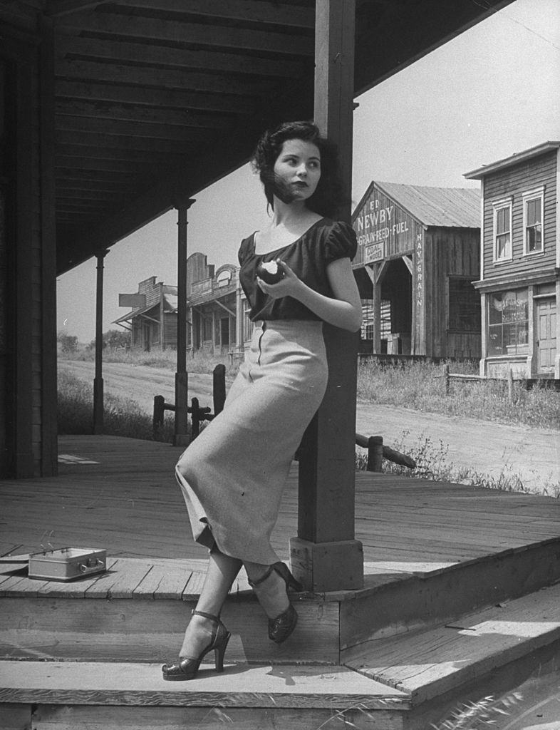 #44 Debra Paget, eating an apple in the shade.