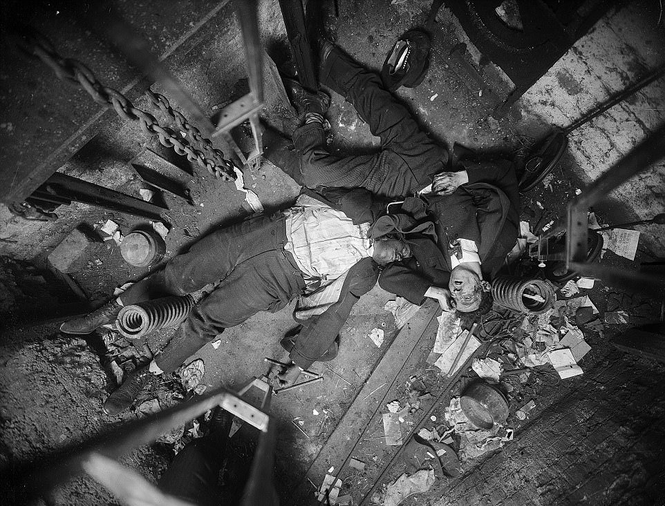 The bodies of Robert Green (left), an elevator operator, and Jacob Jagendorf (right), a building engineer, lie at the bottom of an elevator shaft November 24, 1915, following the pair’s alleged failed robbery attempt
