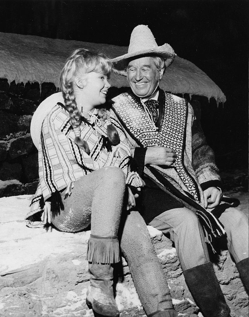 Hayley Mills and Maurice Chevalier, laughing during filming, on the set of the film ‘In Search of the Castaways’, 1961