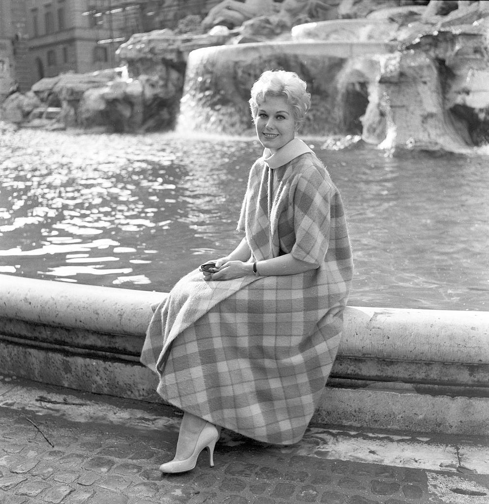#31 Kim Novak sitting on the edge of the Trevi Fountain, Rome, 1957