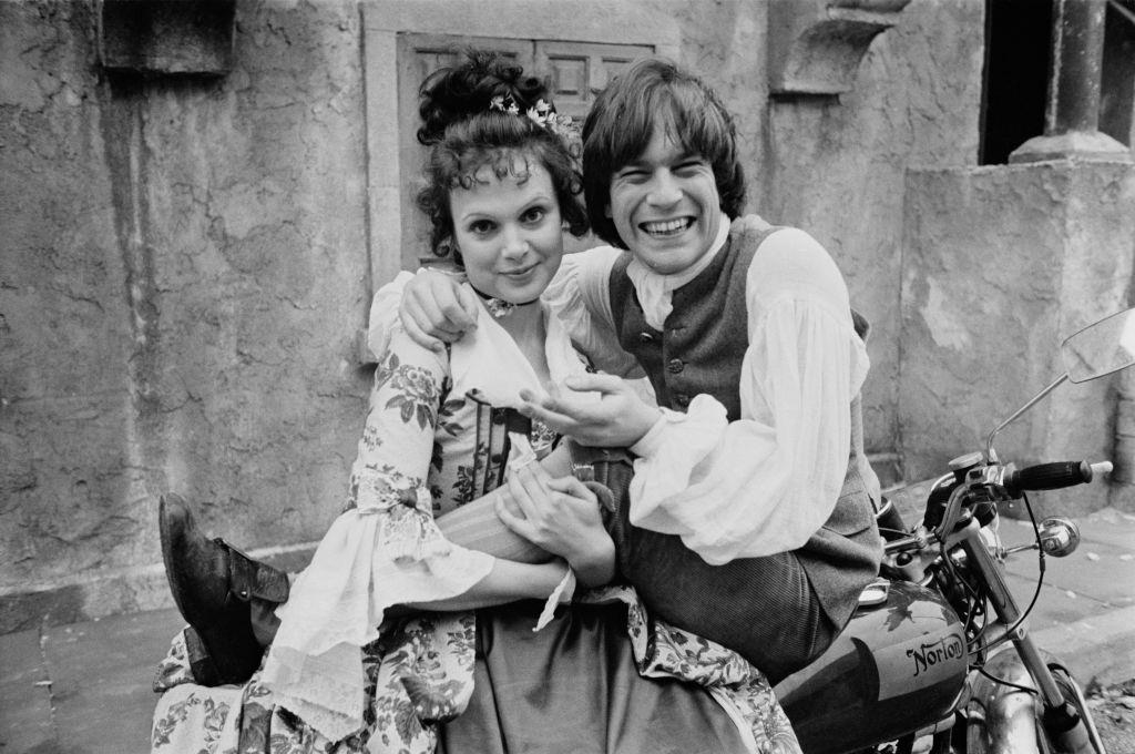 Madeline Smith with Nicky Hanson ‘ on a motorcycle on the set of British comedy film ‘The Bawdy Adventures of Tom Jones’, 1975