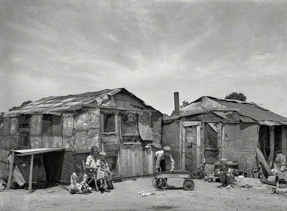 #12 Family in front of shack home, May Avenue camp, Oklahoma City, July 1939
