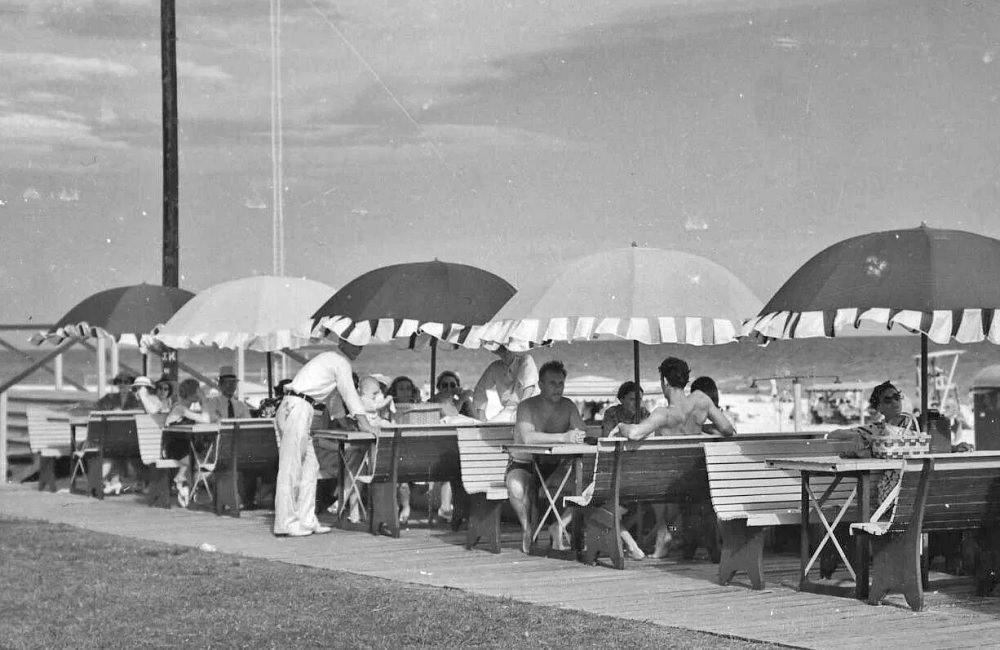 #30 Beachgoers sit under umbrellas at the Pensacola Beach Casino, 1930s