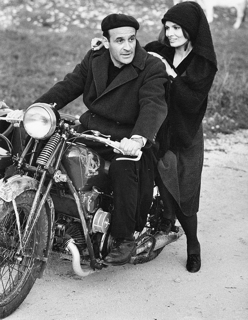 Scilla Gabel with the Italian actor Pier Paolo Capponi on a Guzzi motorcycle on the set of the TV serial ‘Vino e Pane’, Avezzano, 1972