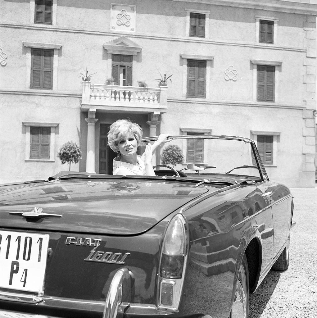 Scilla Gabel in a Fiat 1600 during the filming of “Con rispetto parlando” in Italy, 1965