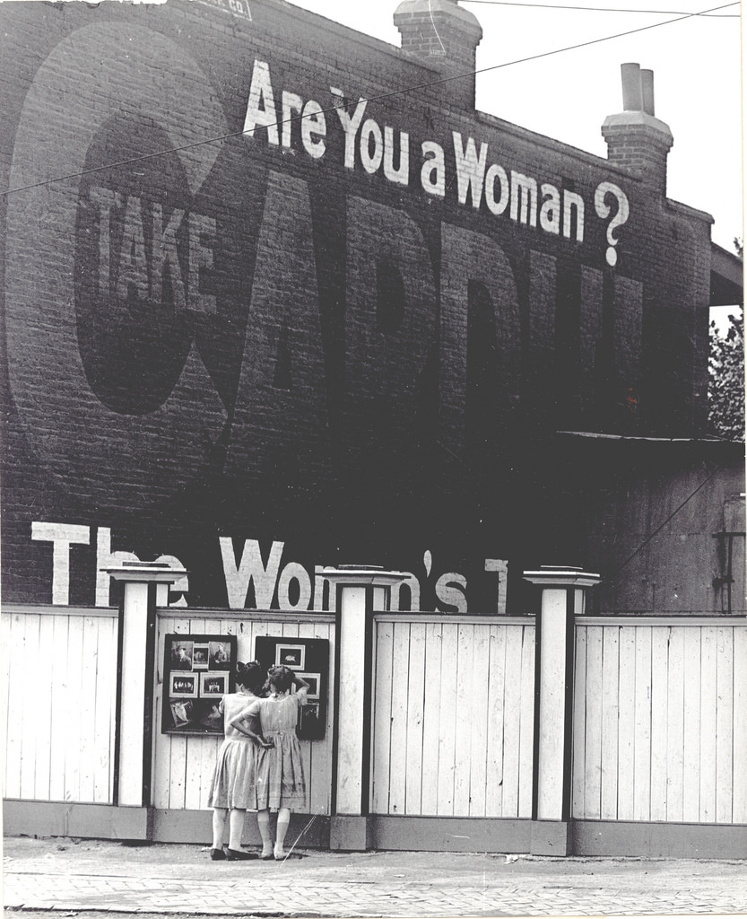 #30 Two girls examining a bulletin board posted on a fence, ca. 1911–1921