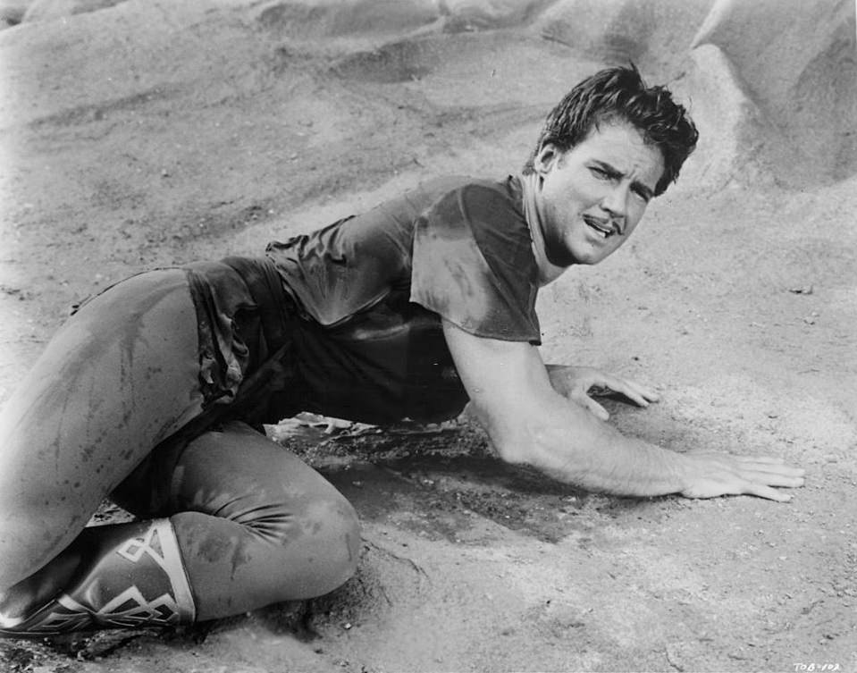 #30 Steve Reeves laying in the sand in a scene from the film ‘The Thief Of Baghdad’, 1961