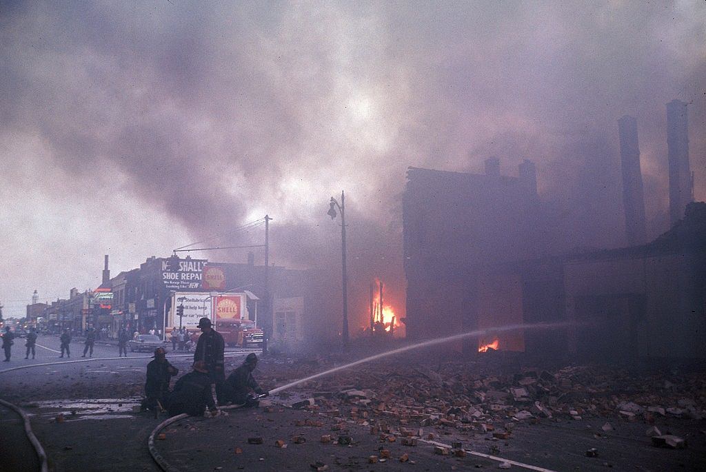 #23 Firemen are protected by police, while they battle smoking blaze after race riots rock the city, 1967