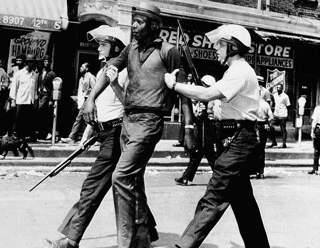 #29 Two police officers in full riot gear arrest a Black man during a breakout of rioting and looting on the West side of Detroit, Michigan, July 23, 1967