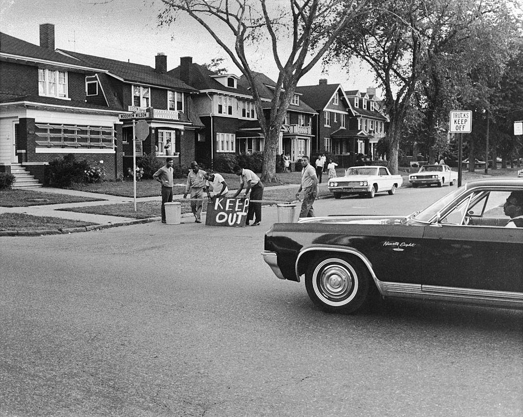 #32 A group of men construct a barricade out of wood and garbage cans to keep their street safe during the riots, Detroit, Michigan, July 27, 1967