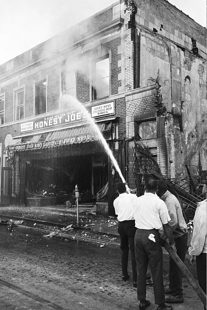 #33 Black residents of Detroit pick up fire hoses dropped by fleeing firemen to put out a fire in their neighborhood, 1967