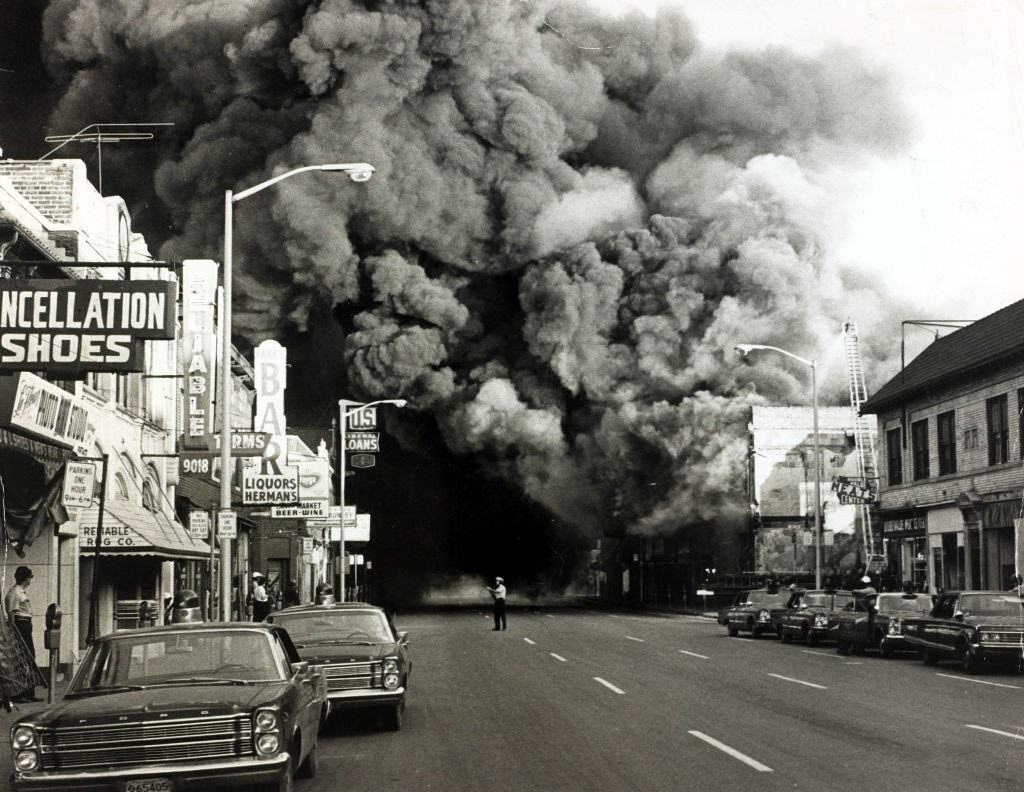 #6 A huge pall of smoke pours from a burning building during race riots in the city, 1967