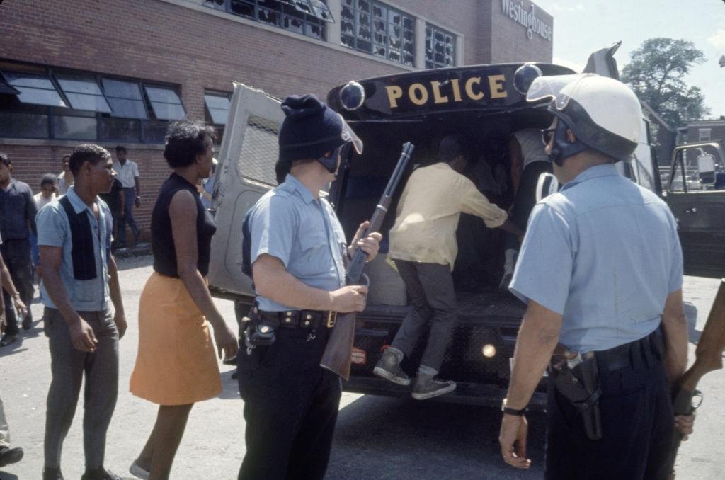 #8 Police officers load suspects into a police van in the wake of ongoing riots , Detroit, Michigan, 1967