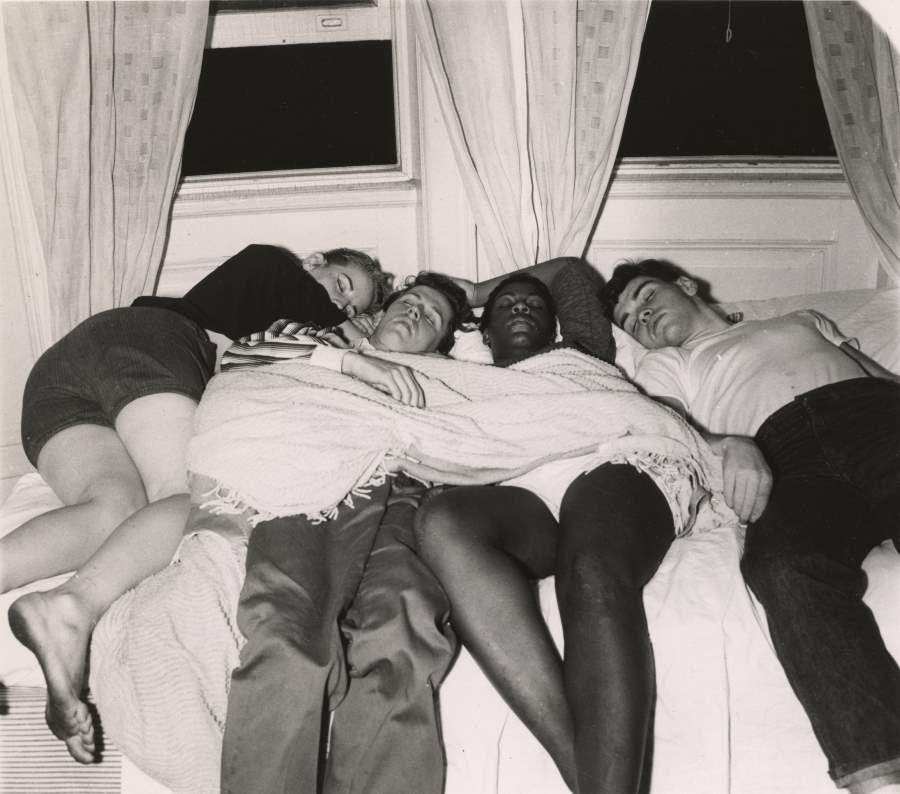 #5 Four friends share a bed in a Greenwich Village apartment after a long night out in 1956.