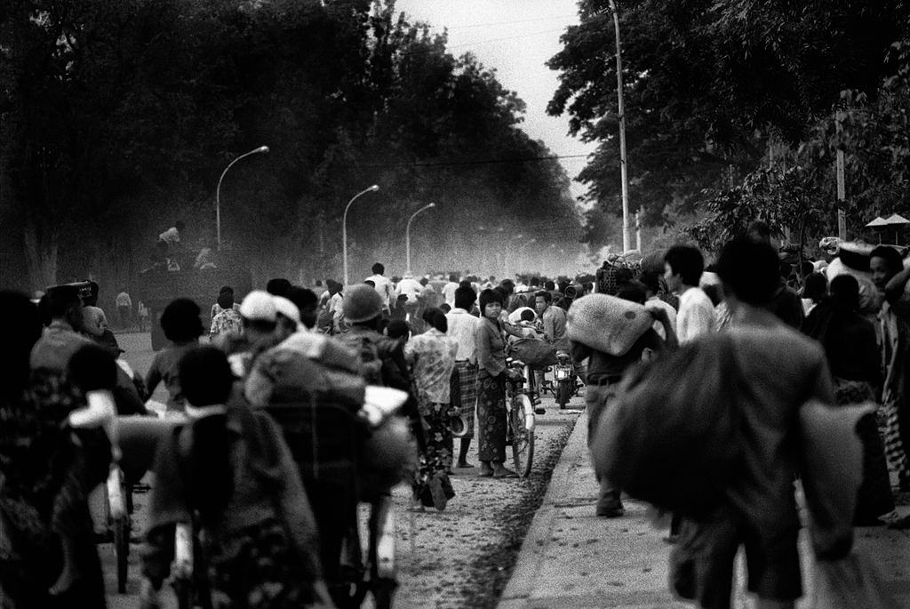 #11 On the evening of the Fall of Phnom Penh to the Khmer Rouge on April 16, 1975 as night fall, thousands of people are streaming towards the center of Phnom Penh on Monivong Boulevard.
