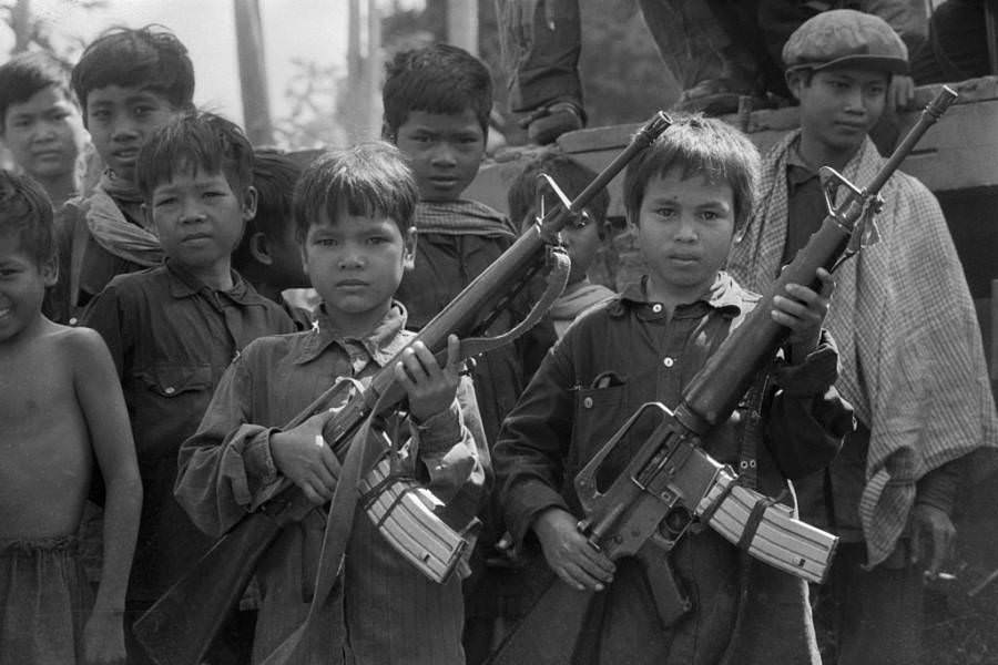 #53 Child soldiers working for the Khmer Rouge show off their machine guns, Galaw, Cambodia. Circa 1979.
