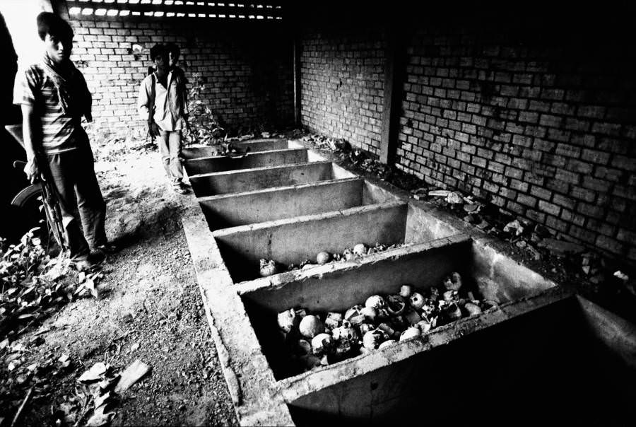#20 A soldier stands by a mass grave, Oudong, Cambodia. 1981.